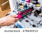 Man changes the printer cartridge in the office. Hand and color detail. Focus in the center.