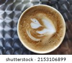 Small photo of Close-up of coffee foam. Isolated over metal pattern background. Top view. Cappuccino coffee with heady froth in a glass mug or cup. Close-up shot of barista coffee cup