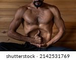 Latin American male yogi sitting practicing Nauli Kriya with Limgan Mudra. Concept of yoga and meditation