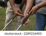 Small photo of Golf instructor teaching how to a female apprentice to adjust her grip