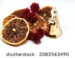 Christmas decorations closeup, golden bell, pines and oranges slices partially slightly unfocused . High quality photo