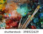 artists brushes and oil paints on wooden palette. Vintage stylized photo of paintbrushes closeup and artist palette. palette with paintbrush and palette-knife
