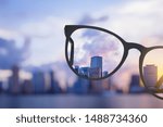 Modern bright city view through eyeglasses. Blurry background. Vision concept