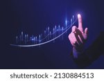 Small photo of Close up of hand pointing at glowing business chart on dark blue background. Stock, market and trade concept. Double exposure