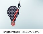 Female standing on abstract pattern light bulb on light background with mock up place. Idea, growth and success concept