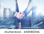 Businessmen shaking hands on abstract city and forex chart background. Teamwork concept. Double exposure