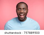 Small photo of Portrait of excited dark skinned man stares at camera, sees what he likes greatly, has bated breath, wears casual clothes, isolated over pink background. Amazed black male model has stunned expression
