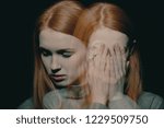 Porter of beautiful redhead girl with psychotic disorders covering her face, hiding from her hallucinations