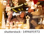 shopping, winter holidays and people concept - happy senior couple at christmas market souvenir shop on town hall square in tallinn, estonia