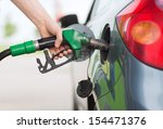 transportation and ownership concept - man pumping gasoline fuel in car at gas station