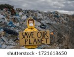 Small child holding placard poster on landfill, environmental pollution concept.