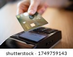 Close up hand of woman paying bill with credit card by contactless. Hand make payment with credit card with NFC technology on terminal device. Mobile payment at coffee shop with card reader machine.