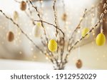 holidays and object concept - close up of pussy willow branches decorated by easter eggs over bokeh lights