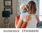 Small photo of Senior woman wearing face mask hugging immunized daughter after covid-19 vaccination shot. Elderly grandmother hugging adult granddaughter after covid vaccine jab. Immunity and end of covid19 pandemic