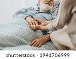 Small photo of Close-up of older dying man holding his wife's hands