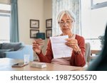 Small photo of Senior woman checking prescription and dosage of medicine. Elderly lady reading medical instructions before taking medicine. Senior woman reading side effects list of drug and contraindications.