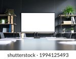 Meeting conference room with blank empty mockup tv screen monitor for advertising standing in modern contemporary office on black wall background. No people. Business technologies concept.
