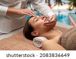 Small photo of wellness, beauty and relaxation concept - beautiful young woman lying with closed eyes and having face and head massage at spa over tropical beach background in french polynesia