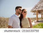 Small photo of travel, tourism and people concept - happy couple in sunglasses over tropical beach background in french polynesia