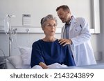 Small photo of Physician listening senior woman back lungs through stethoscope. Hospitalized elderly woman sitting on bed while doctor checking her breathe and heartbeat. Doctor auscultate heart of old patient.