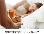 Surprise breakfast for sleeping woman in bed