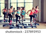 Small photo of fitness, sport, training, gym and lifestyle concept - group of women working out with steppers in gym