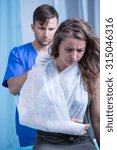 Small photo of Woman with injured hand having tied triangular bandage