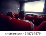 cinema, entertainment, leisure and people concept - couple watching movie in theater from back