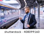 Hipster businessman with smartphone, waiting at the train platfo