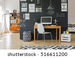 Creative working space with computer desk and accessories in flat with blackboard wall