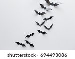 halloween, decoration and scary concept - black paper bats flying over white background