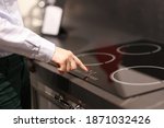 Female finger presses button on touch electric stove. Sale of household appliances koncetp