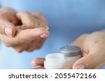 Soft contact lens on finger and storage box closeup