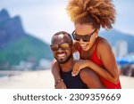 Small photo of head shot portrait young black brazilian couple in piggyback position having fun in Ipanema beach Brazil