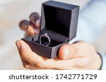 Engagement ring for romantic outdoor elopement marriage proposal when man proposing and holding up an engagement ring in box 