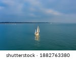 Small photo of Aerial view of a sailing boat sailing up Southampton Water in the United Kingdom on a sunny day. Yacht with four sails including a mizzen, mail and Genoa, space for text.