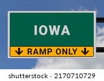 Iowa logo. ?Iowa lettering on a road sign. Signpost at entrance to ?Iowa, USA. Green pointer in American style. Road sign in the United States of America. Sky in background