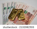Small photo of Estonia - 5.7.2021: Russian rubles banknotes with gold bullion bar. Gold backed financial system of Russia. Russian gold reserves. De-dollarization. World monetary system.