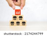 Small photo of Close-up hand choose graph on wooden block stack pyramid with franchise business store icon for franchising to growth branch expansion and business banking loans.