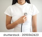 Asian woman checking heart beats with stethoscope. closeup photo, blurred.