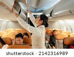 Small photo of Cabin crew or air hostess working in airplane. Airline transportation and tourism concept.