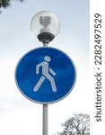 The pedestrian zone road sign is hanging on a street lamp
