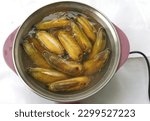Small photo of Ripe yellow bananas boiled in boiling hot water in an electric frying pan