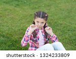 Small photo of Springtime concept. Park and garden. Kid gadabout. Girl little kid spend leisure outdoors in park. Girl sit on grass in park. Child enjoy spring sunny weather while sitting at meadow in park.