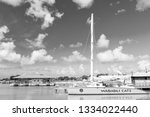 Small photo of Antigua, Antigua and Barbuda - December 13, 2016: modern yellow yacht or sailing boat or marine vessel under bare poles at moorage at pier in sea dock or bay on sunny day on blue sky