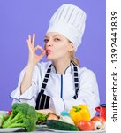 Small photo of The best foods for every vitamin and mineral. Professional cook gesturing ok. Pretty woman chef with vitamin vegetables on table. Kitchen maid preparing vitamin food. Getting vitamin the natural way.