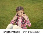 Small photo of Springtime concept. Park and garden. Kid gadabout. Girl little kid spend leisure outdoors in park. Girl sit on grass in park. Child enjoy spring sunny weather while sitting at meadow in park.