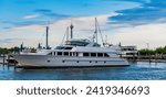 Small photo of Summertime yachting. Yacht vacation in summer. A luxury private motor yacht in sea harbor. Yacht in navigation. Private white luxury anchored off the beach. Summer vacation. Travel vacation