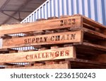Small photo of 2023 Supply Chain Challenges, text written on piled-up pallets, supply chain and logistics management concept