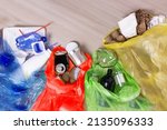 Small photo of garbage sorting by type in colored packages, recycling of environmental waste. Eco friendly people sort garbage. Yellow paper, red metal, green glass, blue plastic.selective focus
